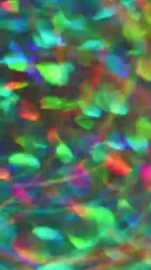 Dikey video. Parıldayan mercek parlıyor. Odaklanamayan parıltı. Çok renkli kırmızı kaleydoskop ışıltısı soyut sanat Bokeh ışığını açıyor bulanık arkaplan.