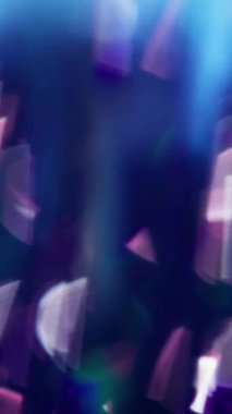 Dikey video. Odaklanmamış parlaklık. Parlayan parçacıklar. Mavi mor pürüzsüz odaklanmış bokeh ışık arka planında parlak beyaz pırıltılı lens.