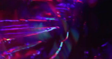 Bulanık parıltı. Neon sızıntısı. Işıldayan kırmızı menekşe kristal yansıma parlaklığı siyah arkaplanda dönüyor. Renkli kaleydoskop parıltısı.