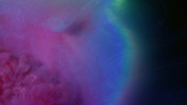 Parıldayan duman. Parlak mürekkep. Mor menekşe parlak sıvı neon renk efekti siyah su arka planında. Odaklanamayan soyut lens.