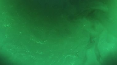 Pigment sıçraması. Boya girdabı. Yeşil mürekkep parıldayan ışın patlaması sisi karıştırıcı sanat sıvısı. Odaklanmamış renk soyut simli akış arkaplanı.