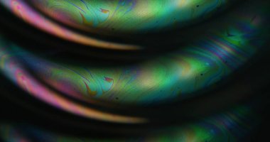 Bulanık yakıt dökülmüş. Yanardöner sanat. Mavi yeşil turuncu renk akışı kimyasal eğri kabarcık boyası soyut koyu siyah arkaplan üzerinde yüzen neon su.