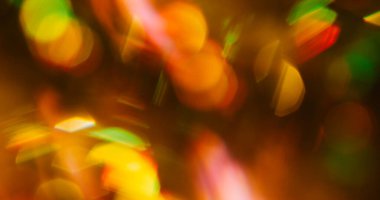 Bokeh gradyan lens. Kaleydoskopik ışık. Siyah arka planda kırmızı sarı parıltı sızıntısı var. Optik parlak renk odaklanmış sanat yansıması.