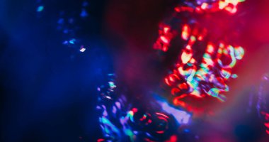 Odaklanamayan ışık lensi. Yansıma flaş dokusu. Siyah arkaplanda kırmızı, mor, parlak renk parlaklığı. Soyut sanat optik efekti.