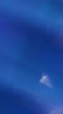 Dikey video. Odaklanmamış yansıma. Ruhsal ışıltı. Soyut parlak beyaz renkli mercek bulanık mavi yeşil bokeh ışık arka planında yüzüyor.