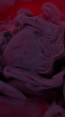 Dikey video. Su altyapısı. Boya rengi. Odaklanmamış mor pembe bulut dokusu dalgası ruhani soyut sanat üzerinde yüzen kimyasal sıvıyı harmanlıyor..