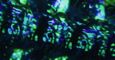 Parıltı söndü. Flaş sızıntısı Yeşil mavi, pürüzlü, parlak bir doku. Siyah arkaplan üzerinde soyut ışıltı kaleydoskop etkisi.