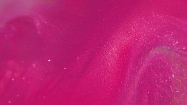 Bulanık boya dökülüyor. Pigment dokusu. Odaklanmamış pembe renk soyut bokeh sanat arka planında akan parlak sıvı emülsiyonu.