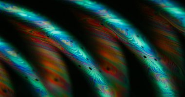 Bulanık madde dökülmüş. Kimyasal mürekkep. Mavi turuncu mor renkli baloncuk siyah eğri emülsiyonu soyut akrilik ışıklı sanat arka planında yüzüyor.