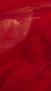 Dikey video. Duman boyası. Buhar bulutu. Su akrilik ışıltılı parçacıklar soyut arkaplanda uçuşurken odaksız kırmızı renk sıçraması.