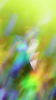 Dikey video. Odaklanamayan kristal parıltısı. Göz kamaştırıcı bir parıltı. Bulanık arka planda gökkuşağı mercekli soyut prizma bokeh ışık yansıması.