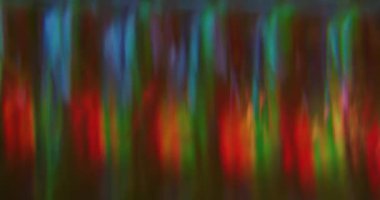 Bulanık parlak sızıntı. Dereceli yansıma. Cam prizmada odaksız renkli şeritli karışık alevler. Soyut kırmızı mavi yeşil parlaklık arkaplanı.