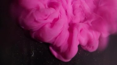 Akrilik bulut. Parlak doku. Parlak, pembe, kıvrımlı, parlak bir sis tabakası soyut siyah sanat arka planına yayılıyor..