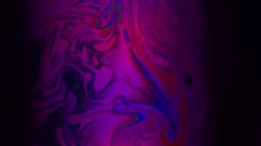 Floresan su mürekkebi. Bulanık spektrum sabunu. Renkli boya dalgası kıvrım sıvısı. Mor kırmızı menekşe benzini soyut arkaplanda yüzüyor.