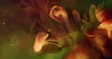 Su altı dumanı. Boya sıvısı. Odaklanmamış pembe renkli duman dokusu soyut bokeh ışık arka planında altın çelenk parlıyor.