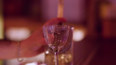 Kokteyl yapımı. Soğuk alkol içeceği. Barmen, sarı likör içen eli metal elek fırlatıyor. Bar tezgahında profesyonel bir içecek hazırlama..