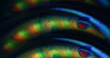 Odaklanamayan sanrısal nokta. Damla sanatı. Soyut arkaplanda yüzen turuncu yeşil neon renkli benzin akrilik pigmenti.