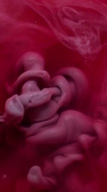 Dikey video. Parıldayan su. Akış parçacıkları. Odaklanmamış kırmızı, mor, sıvı, kimyasal, ıslak mürekkep sıvısı soyut arkaplana dökülüyor..