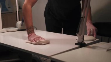 Kuaför salonunu temizliyorum. Virüs önleme. Kadın el tırnağı güzellik spa servisi müşterileri kabul etmeye hazırlanan antiseptik dezenfektanla masayı dikkatlice sterilize ediyor..