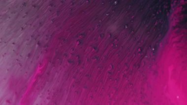 Mürekkep damlası. Renk sıvısı. Odaklanamayan pembe köpüklü su akışı soyut akrilik yaratıcı arka planda koyu siyah dokuya sıçrar.