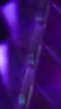 Dikey video. Bulanık parıltı soyut. Renkli üçgenler. Sanatsal ışık arka planında metalik geometrik doku sarı mavi mercek parlaklığı.