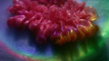 Renkli sis. Işıldayan arka plan. Mor lens demetine pembe turuncu duman tozu mürekkebi dökülmüş. Su, parlak gökkuşağını çözdü..