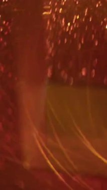 Dikey video. Bulanık girdap parçacıkları. Bokeh geometrik dokusu. Sarı, mor, kırmızı, yeşil daireler. Parlak, çok renkli arka planda parlayan ışık..