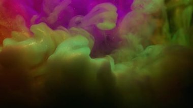 Renkli duman. Boya patlaması. Siyah arkaplanda mor turuncu parlak toz girdap lekesi. Soyut parlayan su dokusu.