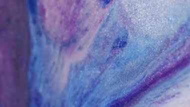 Parlak boya dökülmüş. Parıldayan sıvı dalga. Odaklanmamış mavi mor beyaz renk parıldayan akrilik doku akışı soyut sanat arkaplanı.
