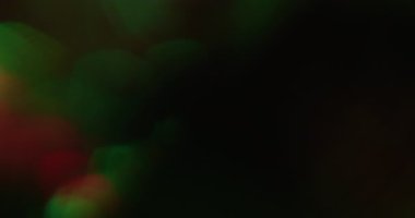 İşaret fişeği bokeh. Kristal titreşimli. Yeşil kırmızı renk çemberi çözünmüş kıvılcımlar yayıyor. Siyah arkaplanda parlayan soyut boşluk.