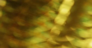 Odaklanamayan kristal titreşimi. İşaret fişeği karışımı. Sarı turuncu ışık dalgalı karışık renk. Yüzeysel prizma parıldayan doku soyut koyu arkaplan.