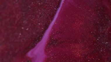 Parlak mürekkep akışı. Parlak sıvı karışımı. Odaklanmamış pembe renk parçacıkları dokusu akrilik emülsiyon sızıntısı soyut sanat arka planı.