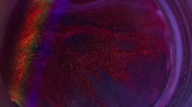 Floresan ışıltısı. Hafif emülsiyon. Odaklanmamış kırmızı mavi renkli yuvarlak mürekkep simli gökkuşağı desenli damlacıklar soyut neon mor arka planda sızıyor.
