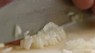 Soğan pişiriyorum. Baharatlı malzeme. Eller kıyma işlemi. Şef keskin profesyonel bıçakla küçük parçalar halinde vejetaryen yemeği doğruyor..