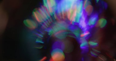 Yuvarlak bokeh prizması. Kaçak aydınlatma. Neon renkli küre siyaha yansıyan kaleydoskop. Mor kırmızı yeşil soyut bulanık arkaplan.