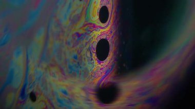 Dikey video. Psikedelik bulanıklık. Yağ pigmenti. Siyah arka planda yarım yuvarlak lens. Soyut yüzen benzin mürekkebi çok renkli sanat sıvısını harmanlıyor.