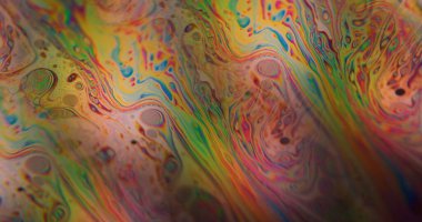 Defocused psychedelic fluid. Oil abstraction. Orange yellow blue color bubble ink water texture floating on acrylic art background.