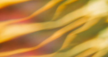 Blurred light flare. Gleam background. Yellow orange red ribbed color texture. Energy wave surface abstract luminosity optical effect.