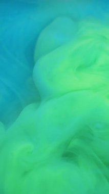 Dikey video. Mürekkep damlası patlaması. Suyu boya. Odaklanamayan mavi renkli ruhani sıçrama sıvısı soyut sanat arka planına yayılıyor..