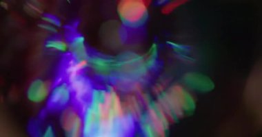 Yuvarlak bokeh prizması. Kaçak aydınlatma. Neon renkli küre siyaha yansıyan kaleydoskop dönüşü. Mavi kırmızı yeşil soyut bulanık arkaplan.