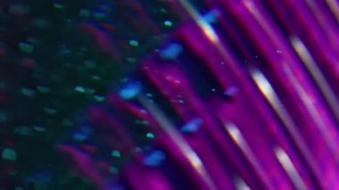 Bulanık ışık dokusu. Parıltılı soyutlama. Odaklanmamış mor floresan görsel neon lens koyu siyah ışıklı arka planda hareket eden optik işaret fişeği.