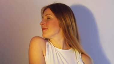 Rahatlama uyumu. Tatmin olmuş bir kadın. Gökkuşağı ışığı fotokopi arkaplanında izole edilmiş pırıl pırıl temiz yüze dokunan memnun kadın.