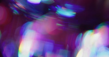 Gradyan Bokeh yansıması. Işıl ışıl parlıyor. Mor mavi kıvılcımlar siyah arka planda karışıyor. Renkli sanat ışını soyut dokusu.
