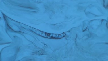 Boya sıçraması. Damlama dokusu. Odaklanmamış mavi beyaz su kimyasalı soyut sanat arka planına yayılan koyu siyah lekeler..