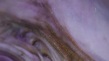 Parlak pigment. Parıldayan mürekkep. Odaklanamayan mor sarı altın rengi su parçacıkları soyut arkaplanda parlayan dokuyu sıçratır.