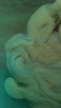 Dikey video. Buhar sanatı. Sis mürekkebi. Tütsülenmiş suda çözünmüş sarı renkli boya. Kimyasal akrilik sıvısı soyut ıslak arka planda yayılıyor..