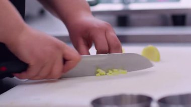 Aşçı kesimi. Sebze doğruyorum. Mutfak tahtasındaki keskin bıçakla patates doğrayan işçi. Profesyonel restoran tekniği servisi..