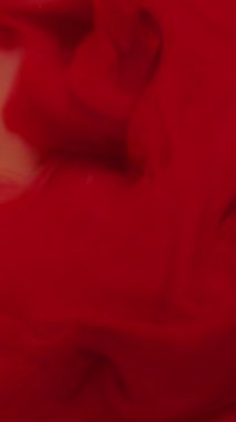 Dikey video. Arkaplanı boya. Renk dumanı. Bulanık kırmızı su sisi kimyasal pigment ıslak doku sıvısı turuncu sanat soyutlaması üzerinde dönüyor..