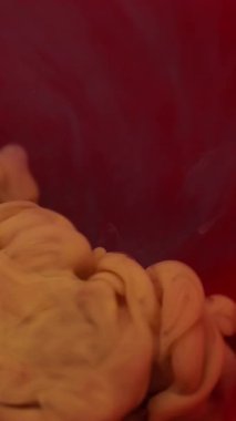 Dikey video. Duman akışı. Soyut mürekkep. Odaklanmamış mor kırmızı renkli duman dokusu yaratıcı arkaplanda yüzen kimyasal sıvıyı harmanlıyor.