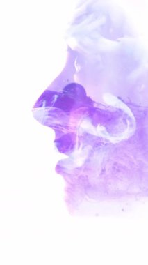 Dikey video. Ruhani siluet. Aydınlanma havası. Mor mavi renkli sis bulutu. İIham dolu kadının profili. Yüzü beyaz boşlukta soyutlanmış..